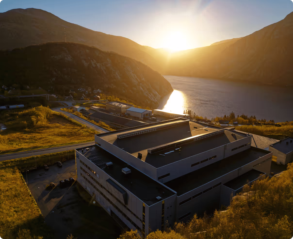 Nscale’s Glomfjord data centre beside the fjord at sunrise.